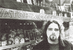 Christopher in front of a clock shop